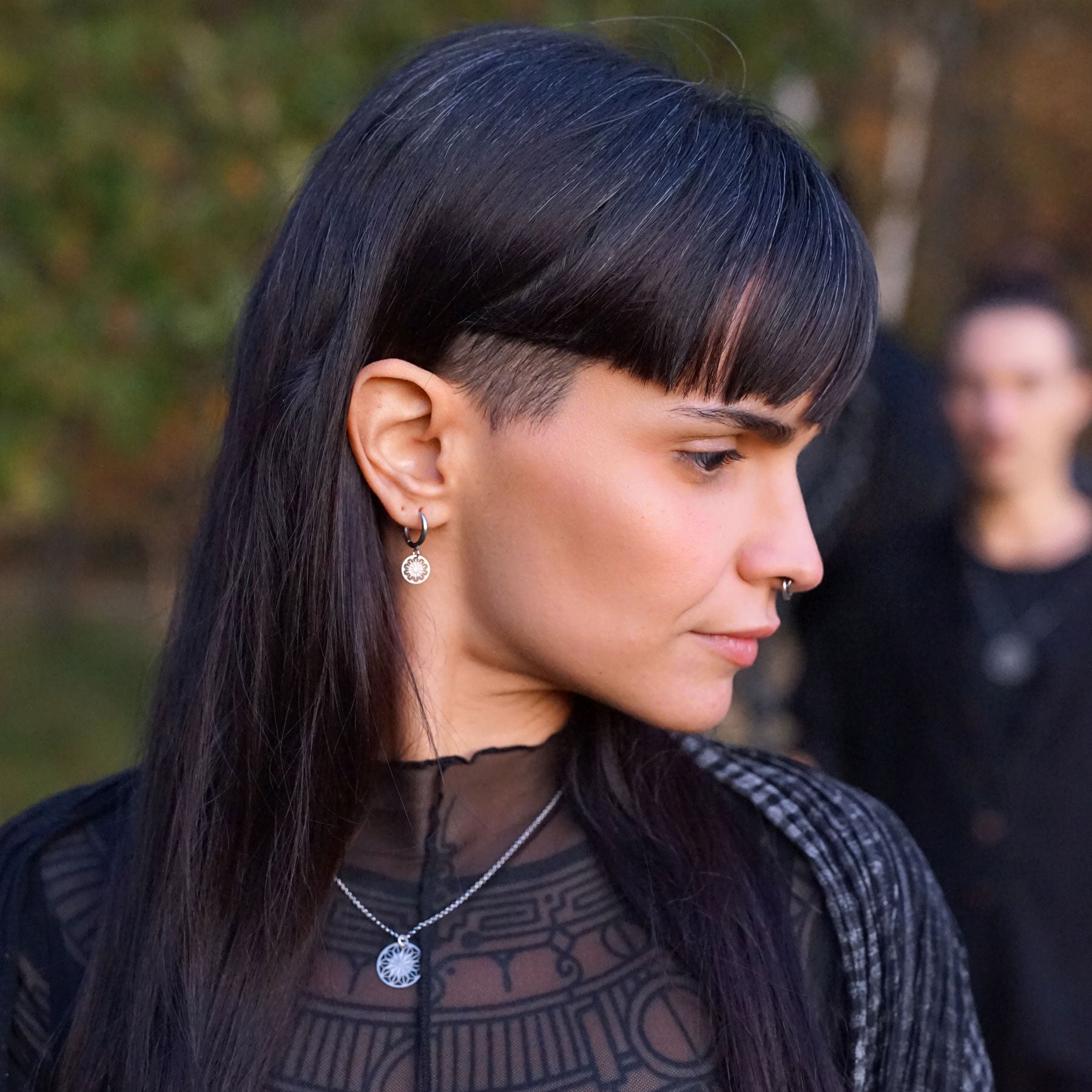 Model Amaya trägt Creolen mit filigranem Anhänger in Edelstahl 